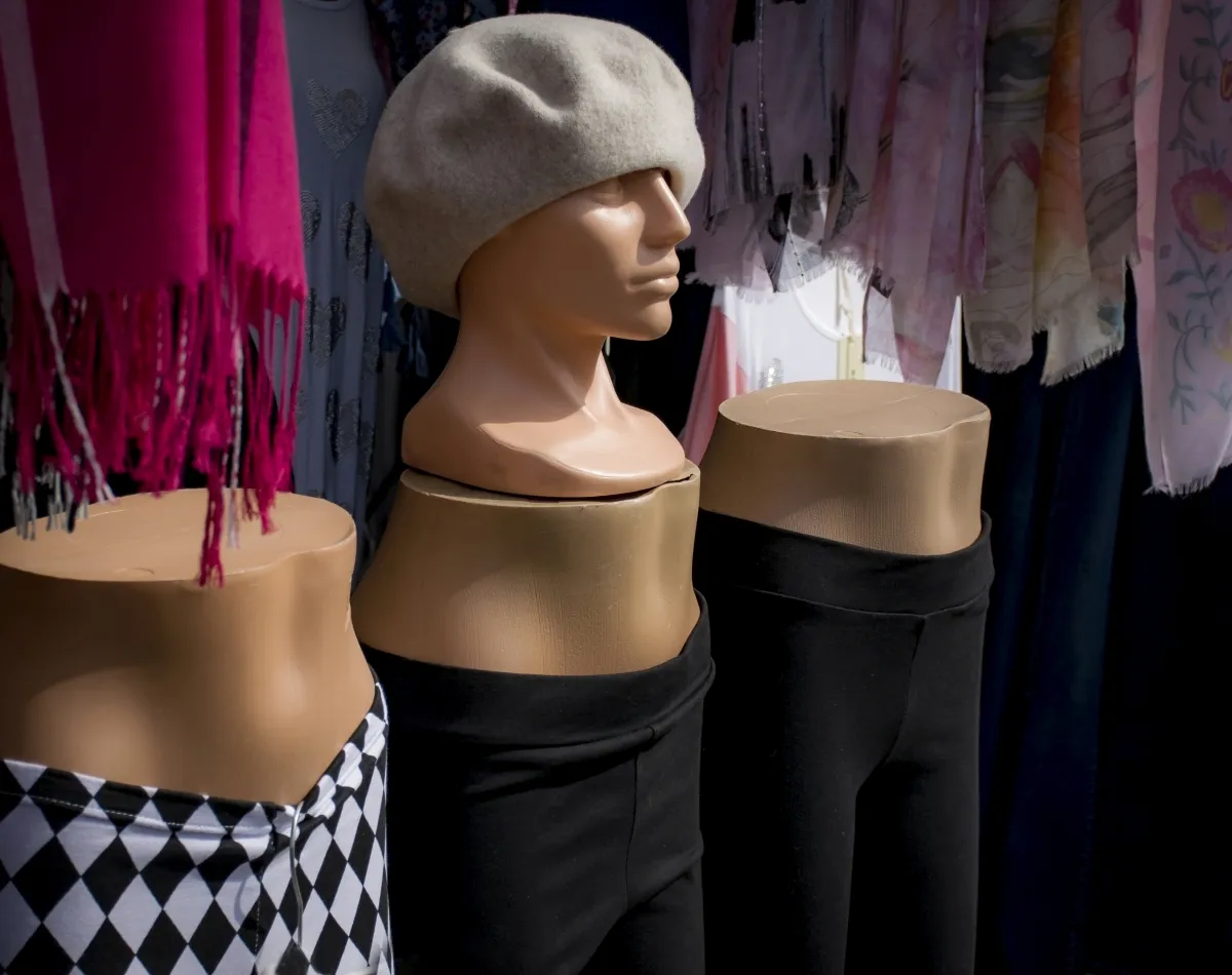 Mannequin heads and torsos in hats and scarves at a street market